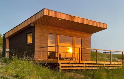 a small house with a large window on a field at 1 Bedroom Stunning Home In Sejerø in Sejerby