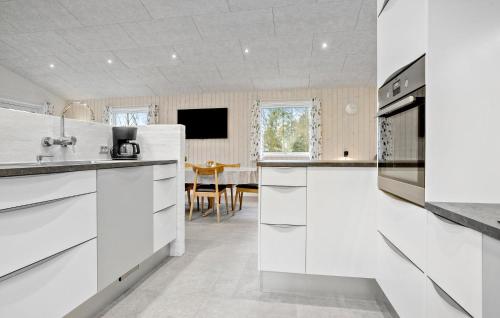 a kitchen with white cabinets and a dining room at Beautiful Home In Spøttrup With Wifi in Spottrup