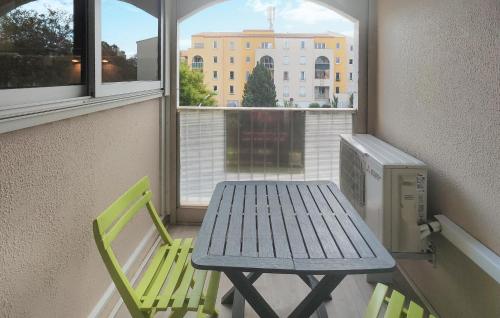 une table et deux chaises dans une pièce avec une fenêtre dans l'établissement 1 Bedroom Lovely Apartment In Agde, au Cap d'Agde