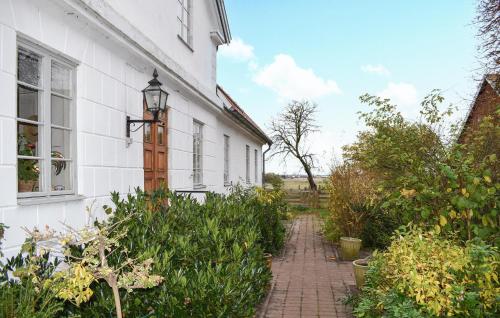 a white house with a brick walkway in front of it at 2 Bedroom Amazing Apartment In Everöd in Everöd