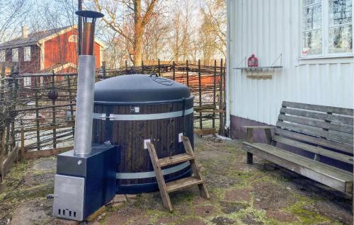 a wood fired stove and a bench next to a building at Awesome Home In Rörvik With Sauna in Rörvik