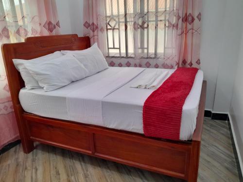 a bed with white sheets and a red blanket at Valley Breeze Hotel in Dar es Salaam