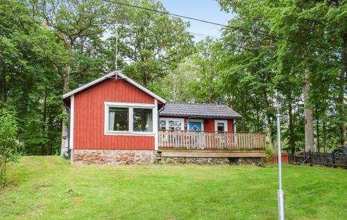 a small red house with a deck in a yard at 1 Bedroom Lovely Home In Lagan in Lagan