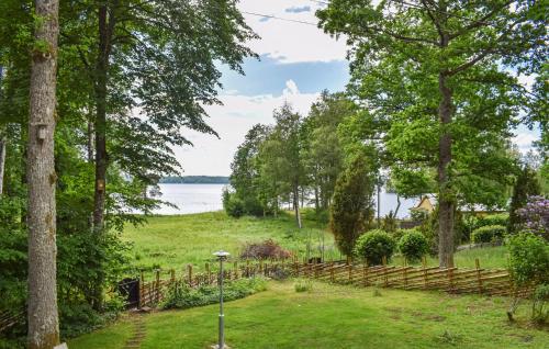 a garden with a fence and a view of the water at 1 Bedroom Lovely Home In Lagan in Lagan