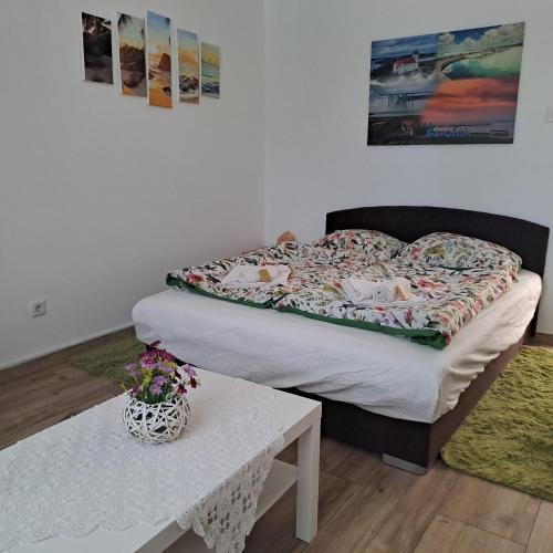 a bed in a room with a table and a bed at Tünde lak in Siófok