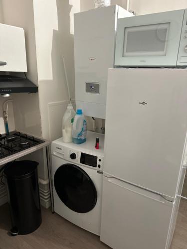 La cuisine est équipée d'un réfrigérateur blanc et d'un four micro-ondes. dans l'établissement Apparemment T1 cosy, à Cabriès