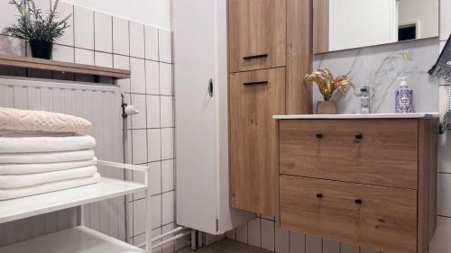 a bathroom with a wooden cabinet and towels at Simon Apartment in Antwerp