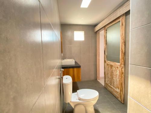 une salle de bains avec toilettes et lavabo dans l'établissement Villa Megadana Munggu, à Canggu
