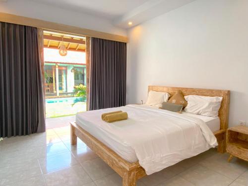 une chambre avec un lit avec un ordinateur portable dessus dans l'établissement Villa Megadana Munggu, à Canggu
