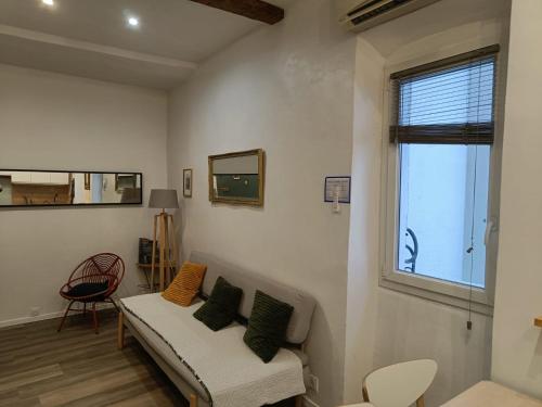 un salon avec un canapé et une fenêtre dans l'établissement Appt 2 chambres au centre ville 4è, à Marseille