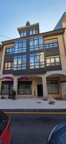 duży budynek z oknami od strony ulicy miejskiej w obiekcie A Bruxo Fonte 8 pzs 2 baños Full Reg VUT38509 w mieście Luarca