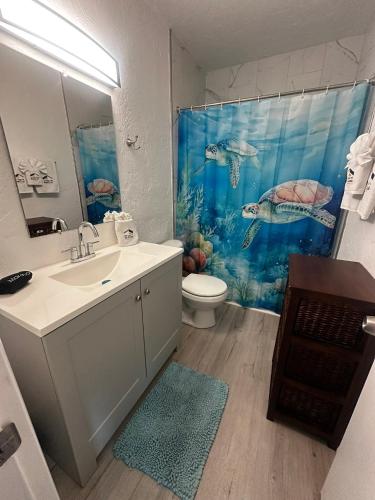 a bathroom with a sink and a shower curtain at Playa Esmeralda suite 4 in Bradenton Beach