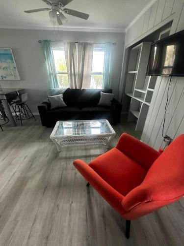 a living room with a red couch and a coffee table at Playa Esmeralda suite 4 in Bradenton Beach