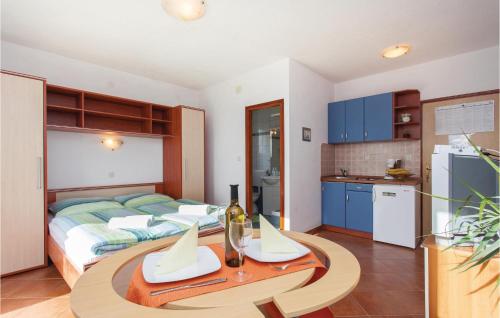 a bedroom with a bed and a table and a kitchen at Lovely Apartment In Kornic With Wifi in Kornić