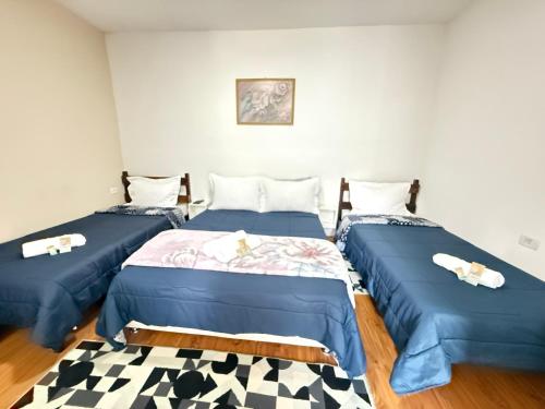 a room with two beds and a rug at Estúdios Recanto Genebra- 15 min Centrinho Turístico in Campos do Jordão