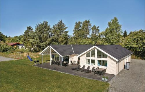 a white house with a porch with chairs and tables at Cozy Home In Vejby With Sauna in Vejby
