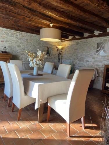 une salle à manger avec une table et des chaises blanches dans l'établissement Maison de vacances, à Nadaillac