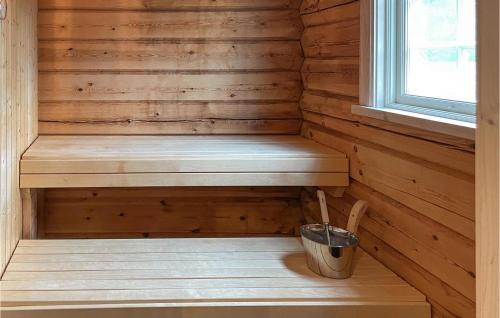a wooden sauna with a bench and a bucket at Lovely Home In Mora With Sauna in Mora
