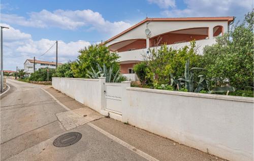 a house on the side of a street with a fence at Two-Bedroom Apartment In Vir in Vir
