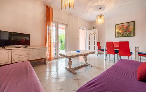 a living room with a tv and a table and chairs at Two-Bedroom Apartment In Vir in Vir