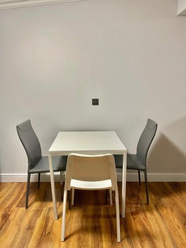 a table with two chairs and a white table and chairs at Comfy Ensuite Room in Colindale in Colindale