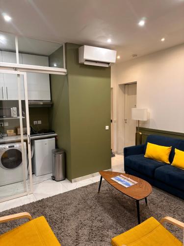un salon avec un canapé bleu et une table dans l'établissement Joli appartement avec cheminée, à Paris