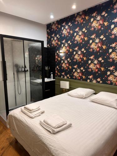 une chambre avec un grand lit avec des serviettes dessus dans l'établissement Joli appartement avec cheminée, à Paris