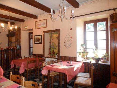 uma sala de jantar com duas mesas e um espelho em Auberge La Bergerie em Sainte-Marie-de-Campan