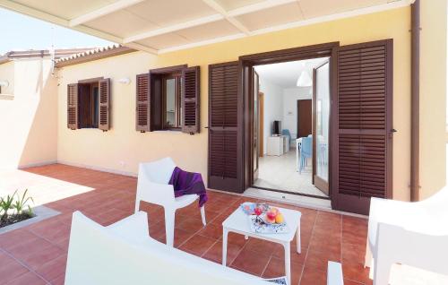 eine Terrasse mit einem Tisch und Stühlen sowie ein Haus in der Unterkunft 2 Bedroom Nice Home In Marina Di Modica in Marina di Modica