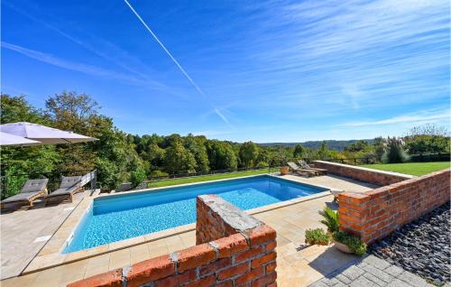 a swimming pool in a yard with a brick wall at Holiday Home Gradec in Brežane Lekeničke