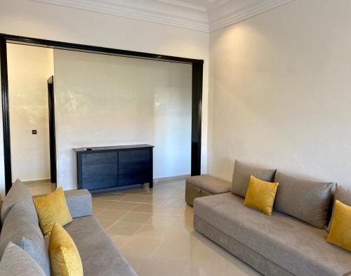 a living room with a couch and a television at Appartement Vue Panoramique sur la siesta plage WELCOME STAY in Mohammedia