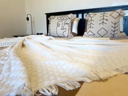 a bed with a white blanket and pillows on it at Appartement Vue Panoramique sur la siesta plage WELCOME STAY in Mohammedia