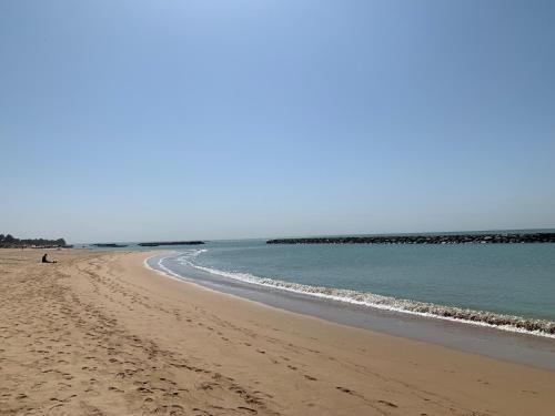 plaża z osobą siedzącą na piasku w obiekcie App el malick w mieście Saly Portudal