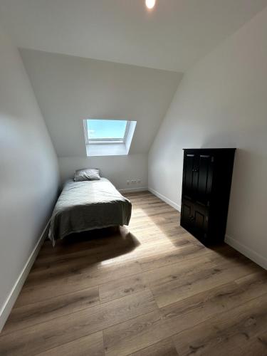 - une chambre avec un lit et une fenêtre mansardée dans l'établissement Modern renovated apartment #8 with 7pers mezzanine, à Cherbourg en Cotentin
