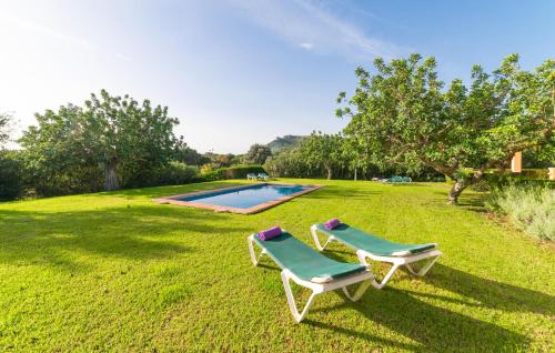 two chairs sitting in the grass near a swimming pool at Can Ullastre in Son Servera