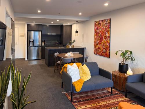a living room with a blue couch and a kitchen at Urban Retreat - 2 BDR 2 BTH Apartment in Phillip