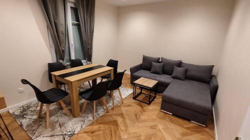 a living room with a couch and a table and chairs at Très bel appartement à Paris et La Défense in La Garenne-Colombes