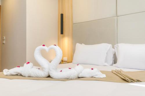 three swans made out of towels on a bed at Tiye Pyramids Hotel in Cairo