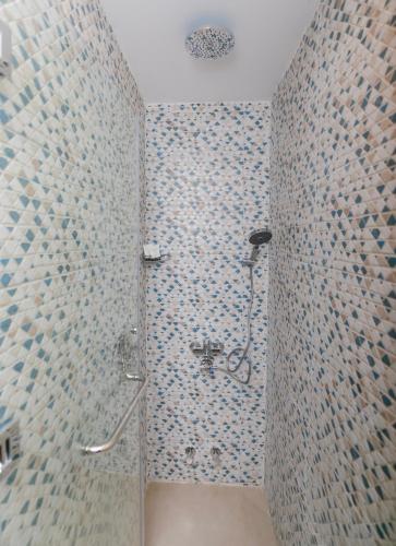 a bathroom with a shower with blue mosaic tiles at Tiye Pyramids Hotel in Cairo