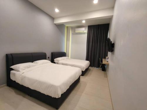 a hotel room with two beds and a window at Room 2 U Hostel & Guest House in Muar