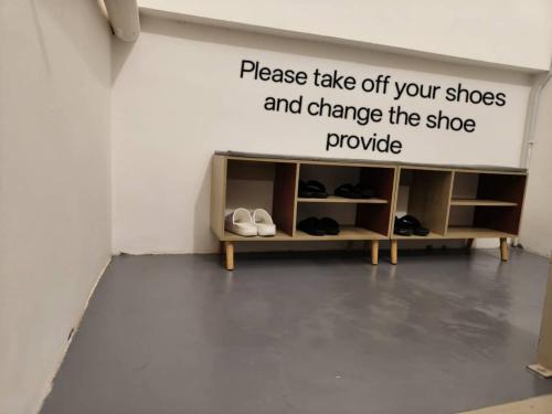 a room with a sign that reads please take off your shoes and change the shoe at Room 2 U Hostel & Guest House in Muar