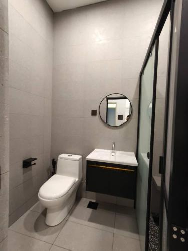 a bathroom with a toilet and a sink and a mirror at Room 2 U Hostel & Guest House in Muar
