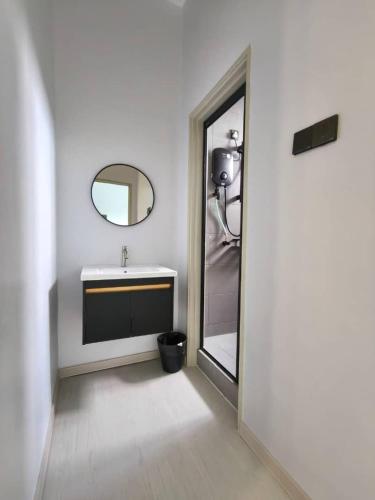 a white bathroom with a sink and a mirror at Room 2 U Hostel & Guest House in Muar