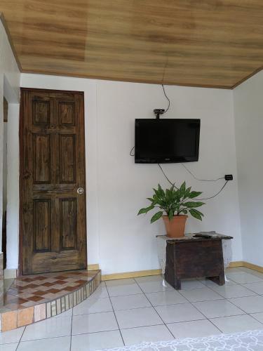 a room with a door and a tv on a wall at Casa Victoria in Puntarenas