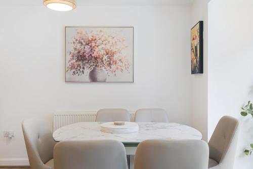 a white dining room with a table and chairs at Pristine house near Dartford Station with Free Parking and Study in Dartford