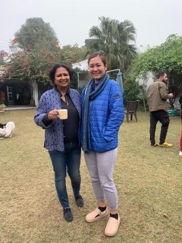 two women standing next to each other in a yard at Green Serene Abode in Meerut