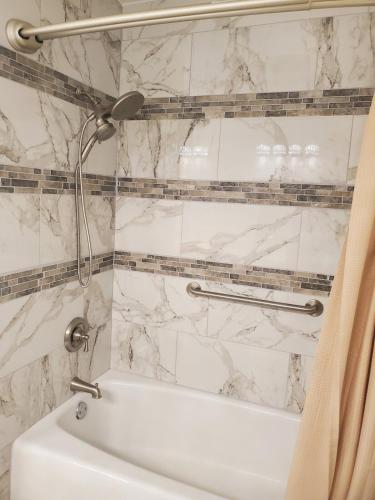 a white bathroom with a shower and a white tub at Casa Del Lago Camping, Jetski docks, Personal dock in Moses Lake
