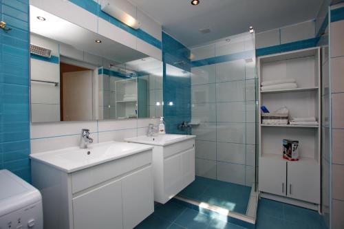 Villa Liogerma في بانورموس سكوبيلوز: حمام به مغسلتين ومرآة