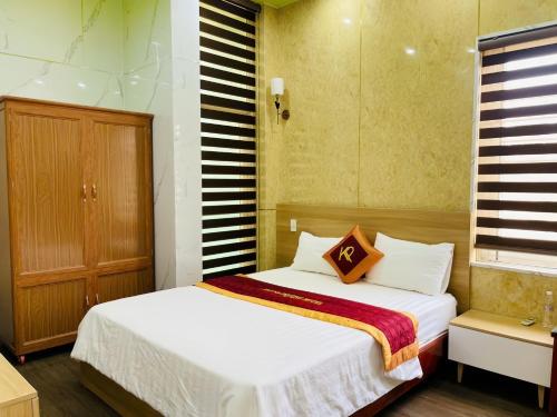 a bedroom with a white bed with a striped wall at Khách sạn Khánh Phương in Quảng Trị