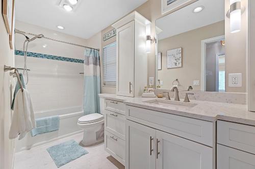 a white bathroom with a toilet and a sink at Dockside Serenity in Palm Coast